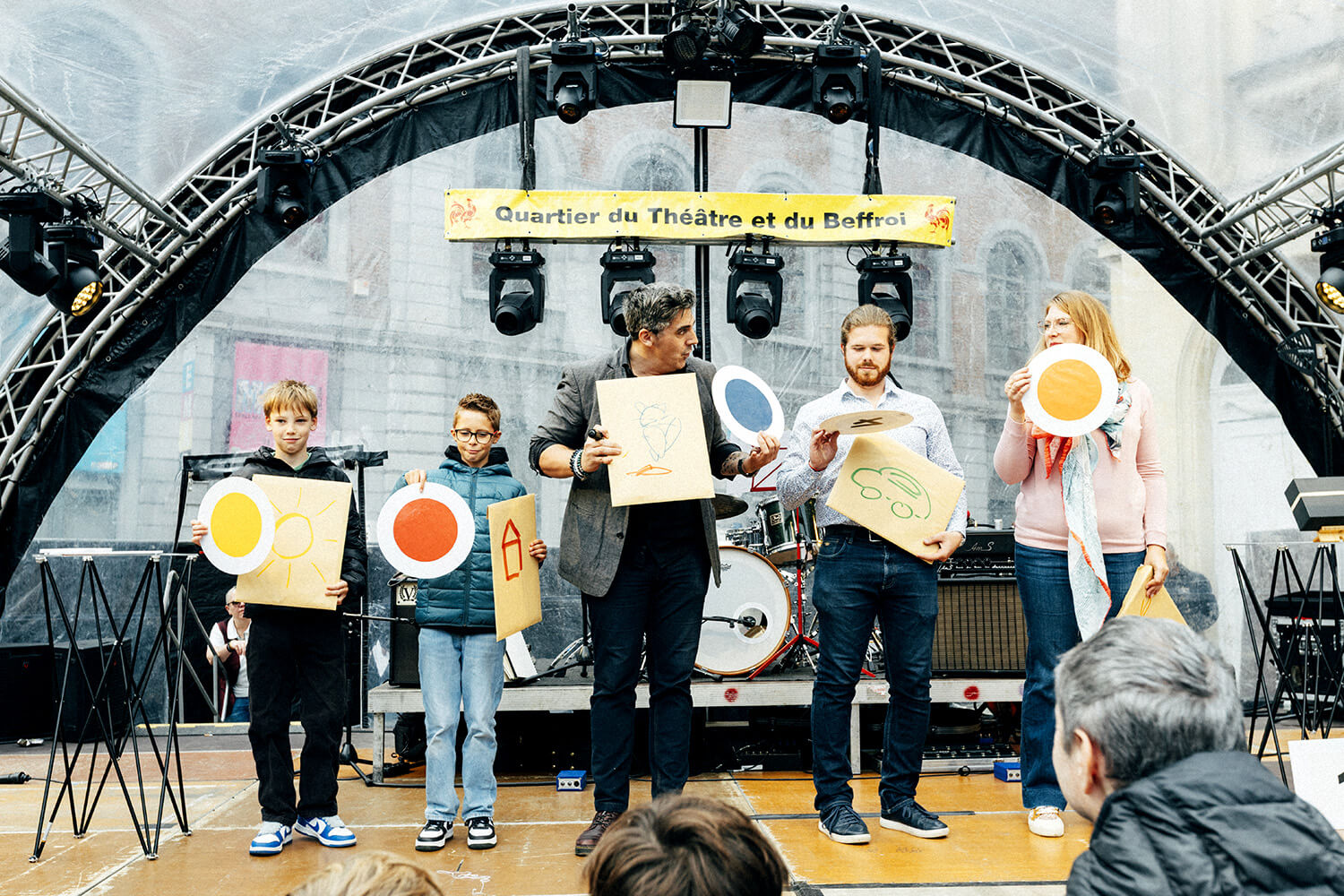 Benjamin Ghislain et des spectateurs, dont des enfants, présentent les dessins réalisés lors de l'illusion de mentalisme.